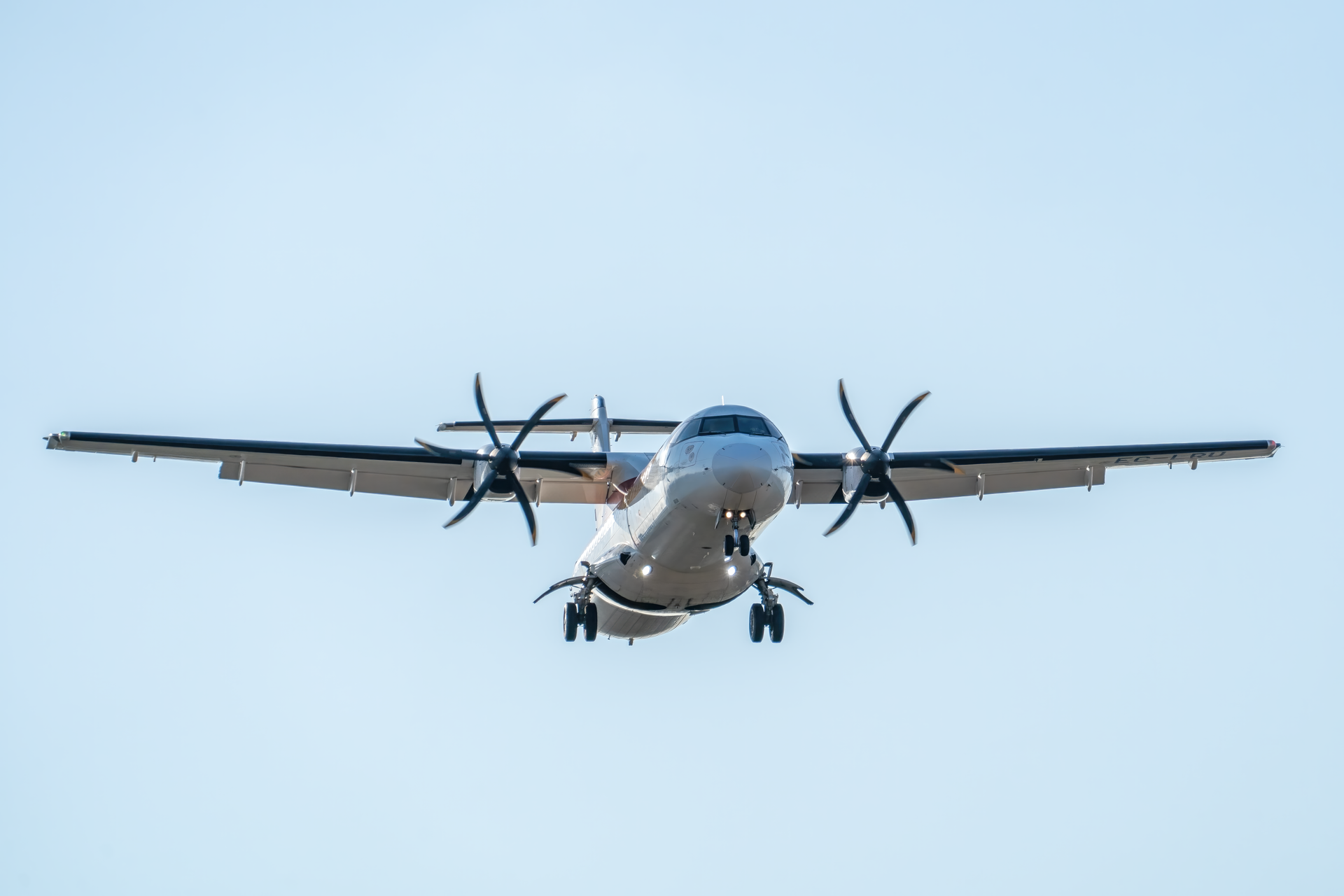 ATR 72 aircraft captured mid-flight with landing gear down at Manises Airport, Spain.