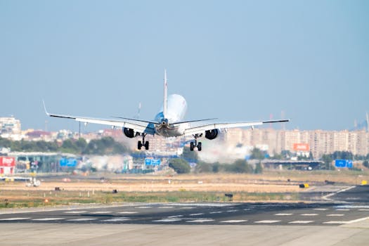 An airplane lands on a sunny day at Manises Airport, Valencia, showcasing aviation in action.