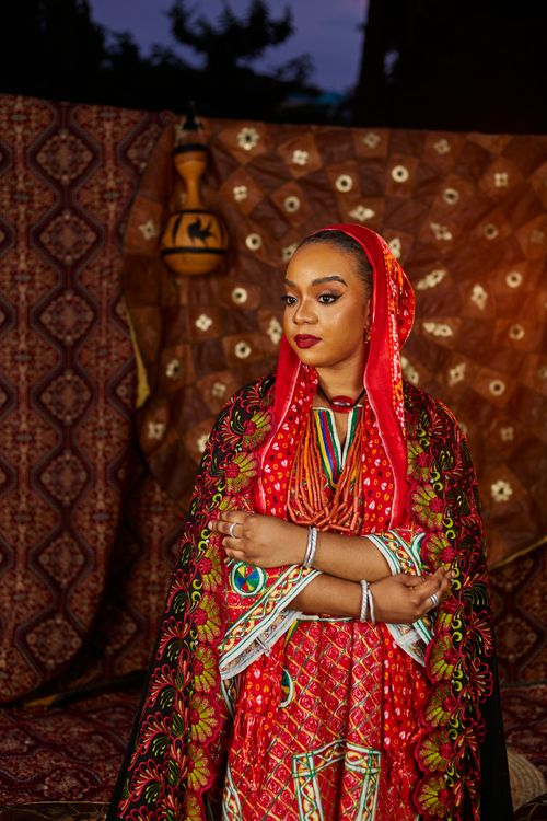 Free Woman in red traditional African attire with vibrant patterns and headscarf Stock Photo