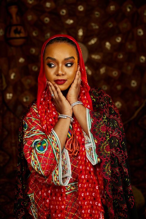 Free Elegant portrait of a woman in vibrant red traditional attire, exuding cultural heritage. Stock Photo