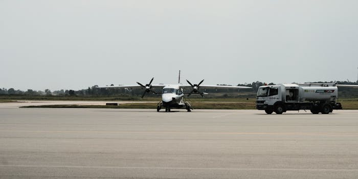 A turboprop aircraft stands on the tarmac beside a fuel truck at Mwanza Airport in Tanzania.