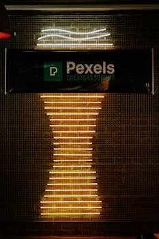 Illuminated neon sign display at Pexels Creators Summit with abstract design.
