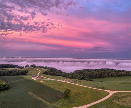 Stunning aerial view of Alma, Wisconsin with vibrant sunset sky, rolling hills, and farmland.