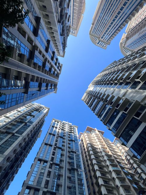 Free A view of skyscrapers reaching for the sky with a clear blue canopy overhead. Stock Photo