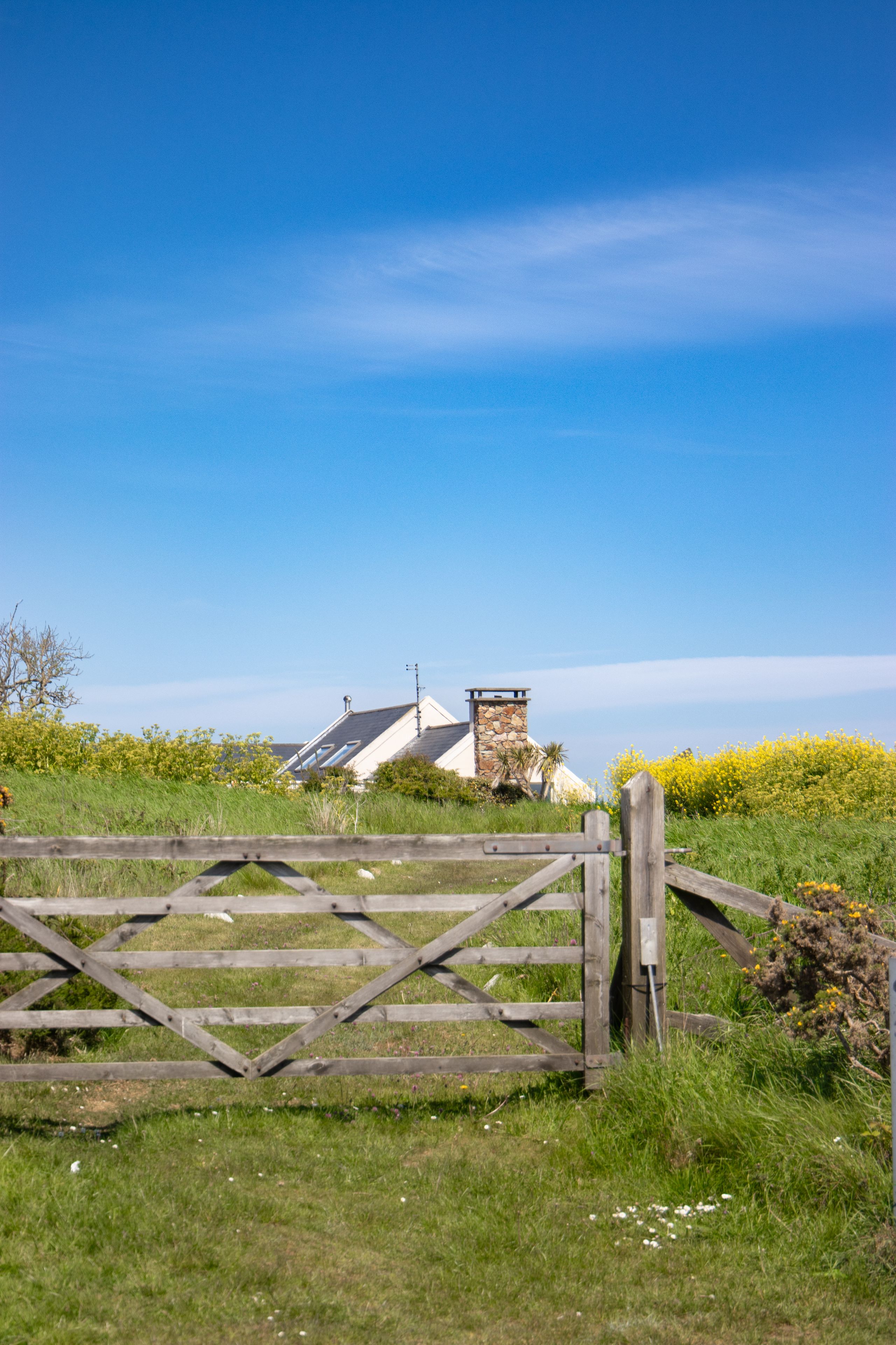 Brown Wooden Fence Across Crop Field Near Body of Water · Free Stock Photo