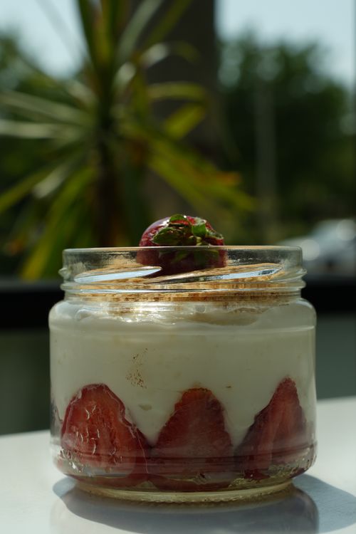 Free Close-up of a strawberry yogurt parfait in a glass jar with a fresh strawberry on top. Stock Photo