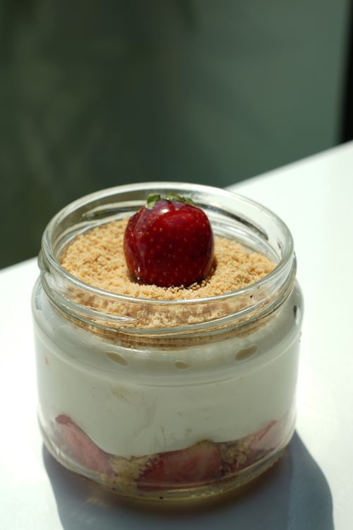 Free A tasty strawberry cheesecake in a glass jar with crumb topping, perfect for dessert lovers. Stock Photo