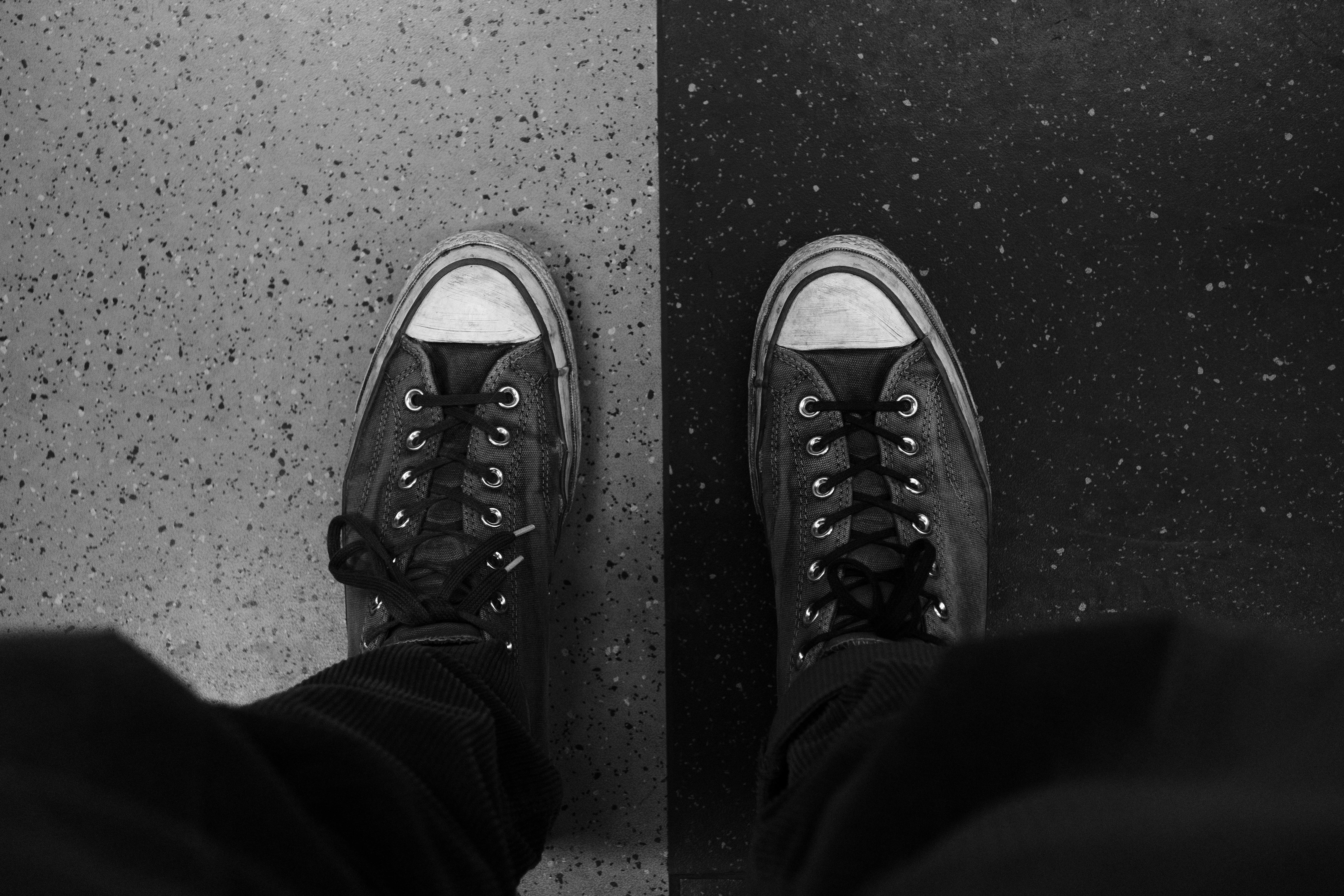 Gratis Et par sneakers på et sort og hvidt gulv i kontrastfarver. Lagerfoto