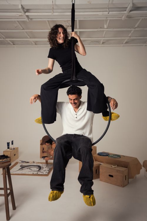 Free Two adults performing creatively on an aerial hoop in a studio setting, exuding fun and skill. Stock Photo