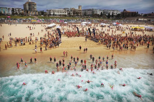 这是一场充满活力的海滩游泳赛事，游泳者们跃入晴空下的大海