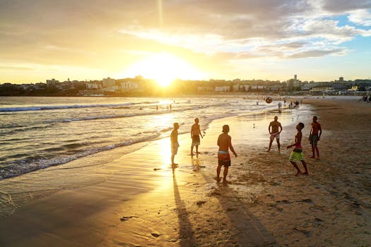 Group enjoying a lively beach volleyball game during sunset, capturing the essence of summer fun.