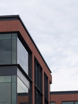 Contemporary brick and glass office building under a cloudy sky.
