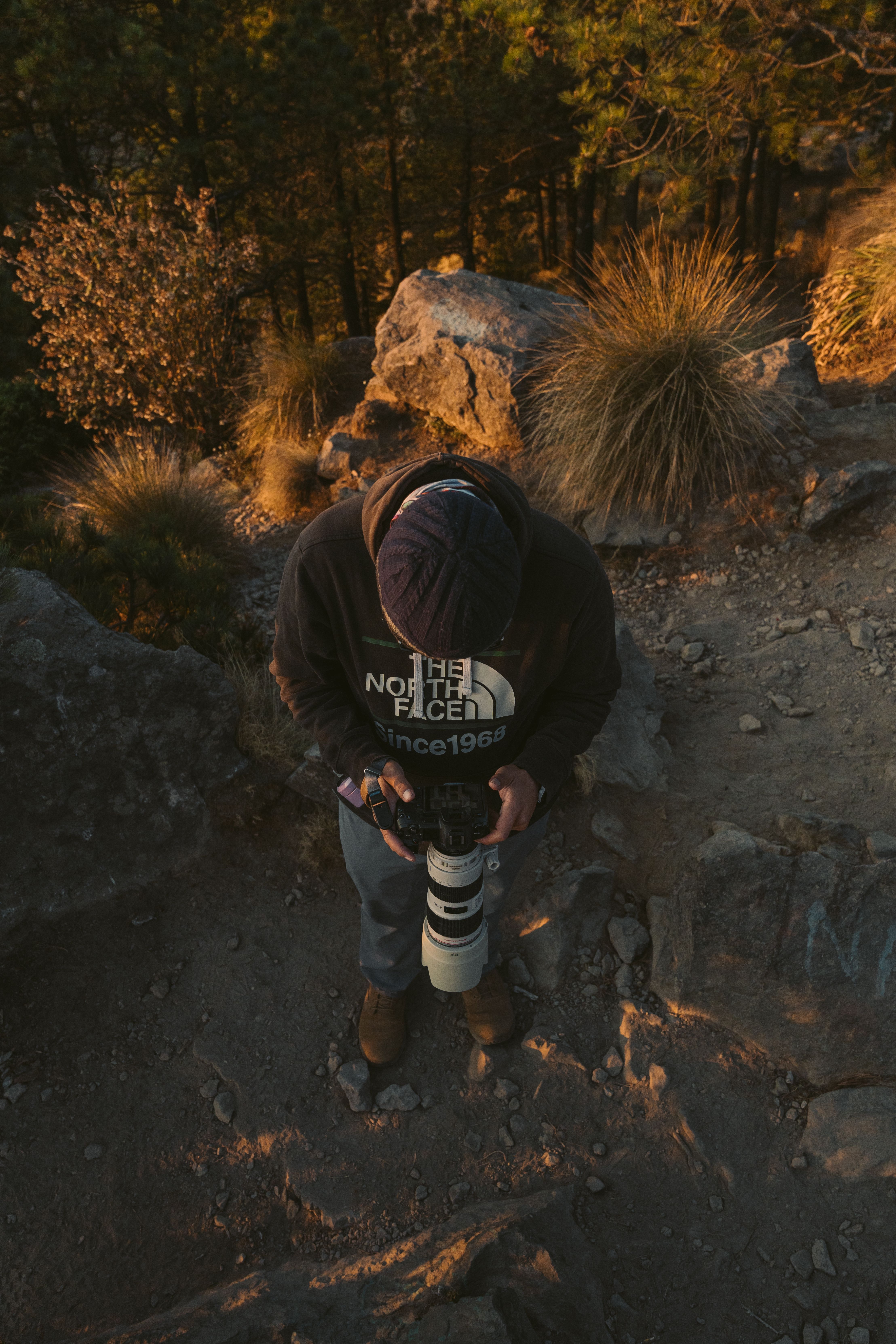 Photographer with camera and zoom lens capturing scenic views in Mexico's rugged terrain.