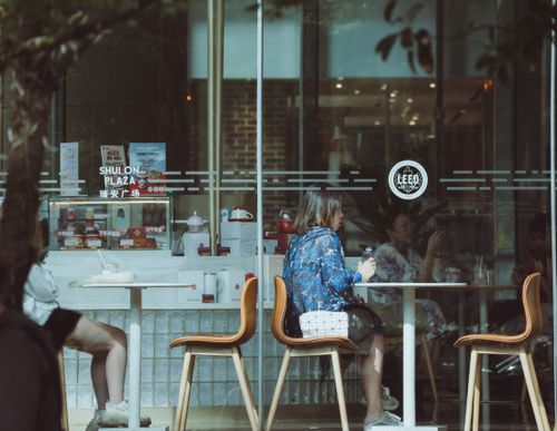 Free Two people enjoying a casual meal at a cafe with glass windows and warm atmosphere. Stock Photo