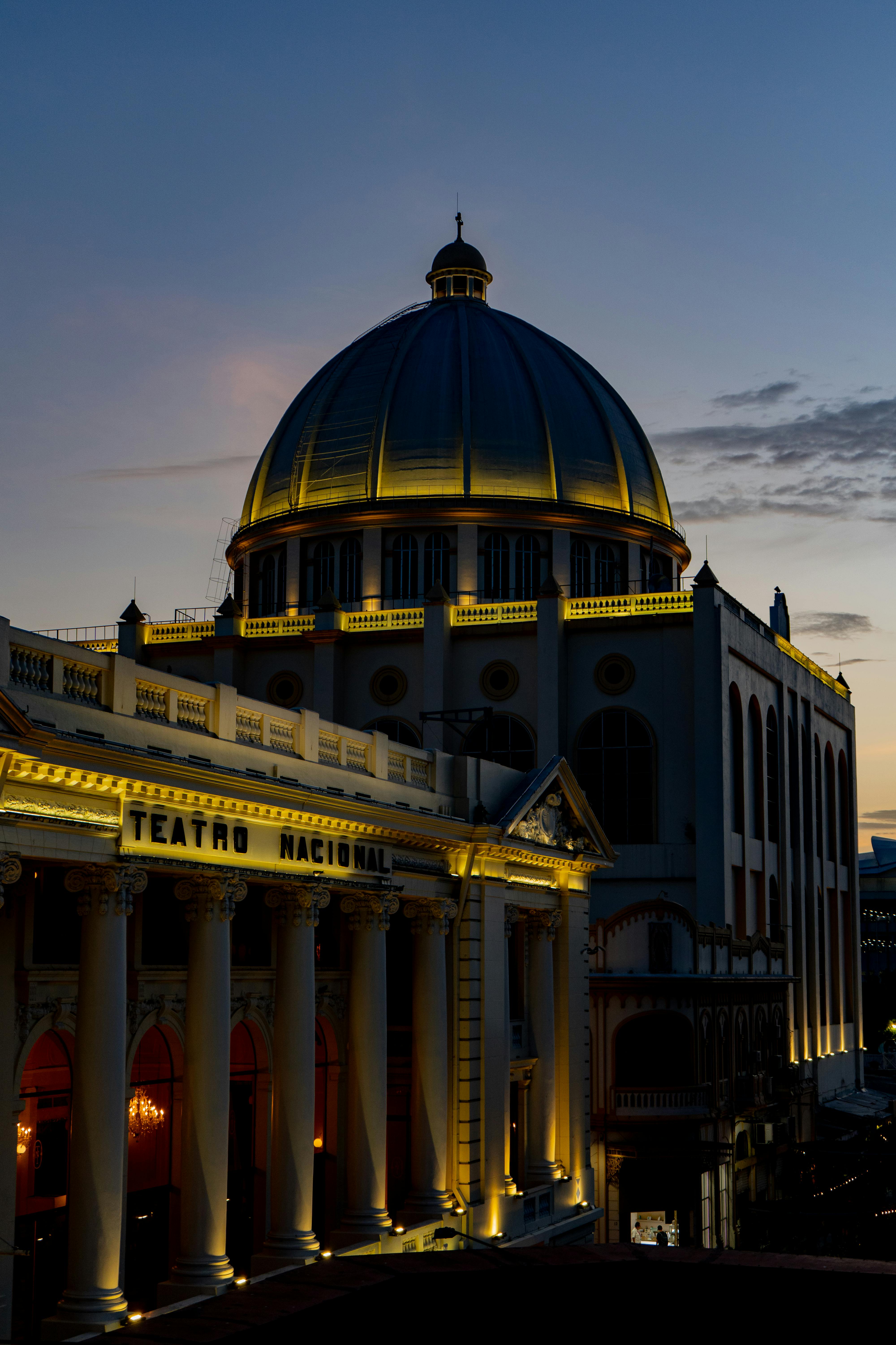 Free A stunning view of the National Theater of El Salvador illuminated against the evening sky. Stock Photo