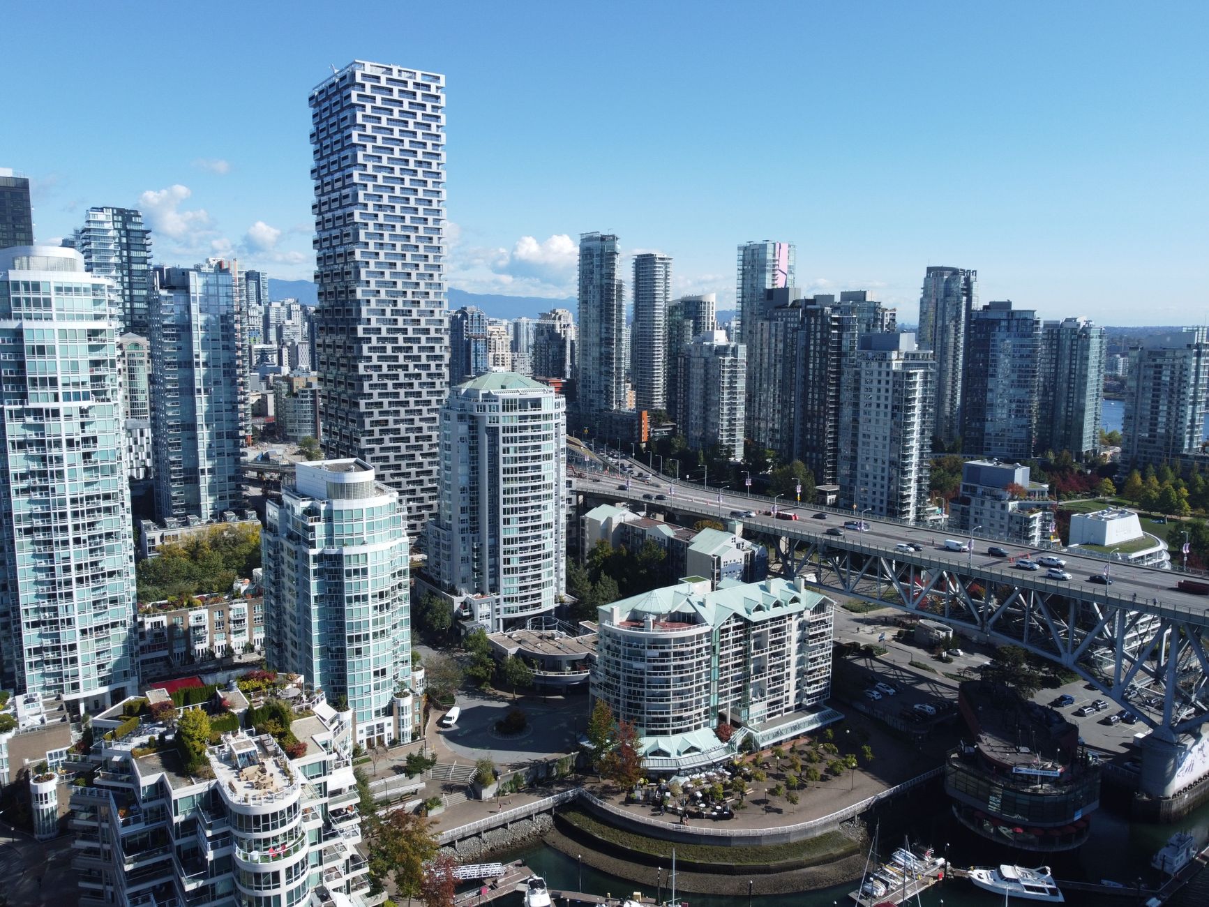 A stunning aerial view of Vancouver's skyline during daytime, showcasing modern architecture and bustling city life.