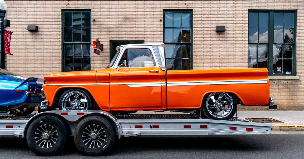 Classic orange pickup truck on trailer in front of brick building, Bristol, Tennessee.