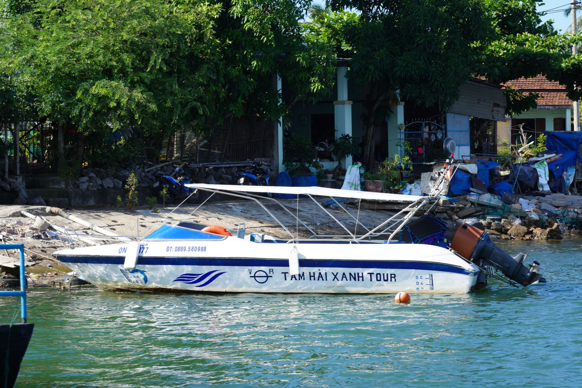 Speedboat at riverbank under clear blue sky, ideal for travel and adventure themes.
