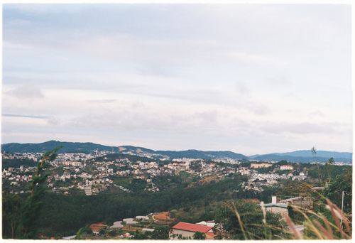 Free Scenic view of a rural hillside community under a blue sky, showcasing peaceful countryside living. Stock Photo