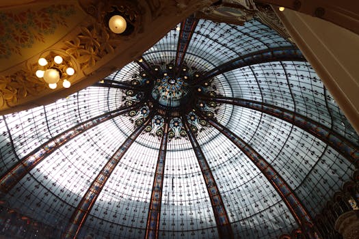 Intricate glass dome ceiling showcasing classic architecture in an elegant indoor setting.