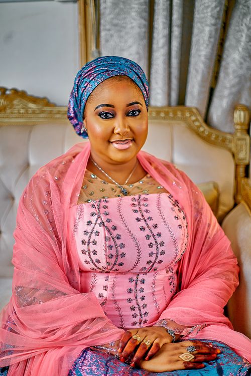 Free Beautiful woman in colorful traditional African attire sitting on a luxurious sofa indoors. Stock Photo