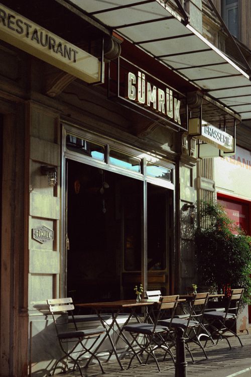 Free Quaint outdoor café with empty seating and signage, perfect for urban dining scenes. Stock Photo