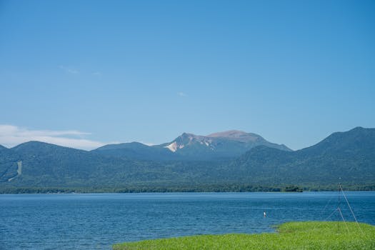 Beautiful clear day at Lake Akan, Hokkaido, Japan with the tranquil blue waters and mountainous backdrop.