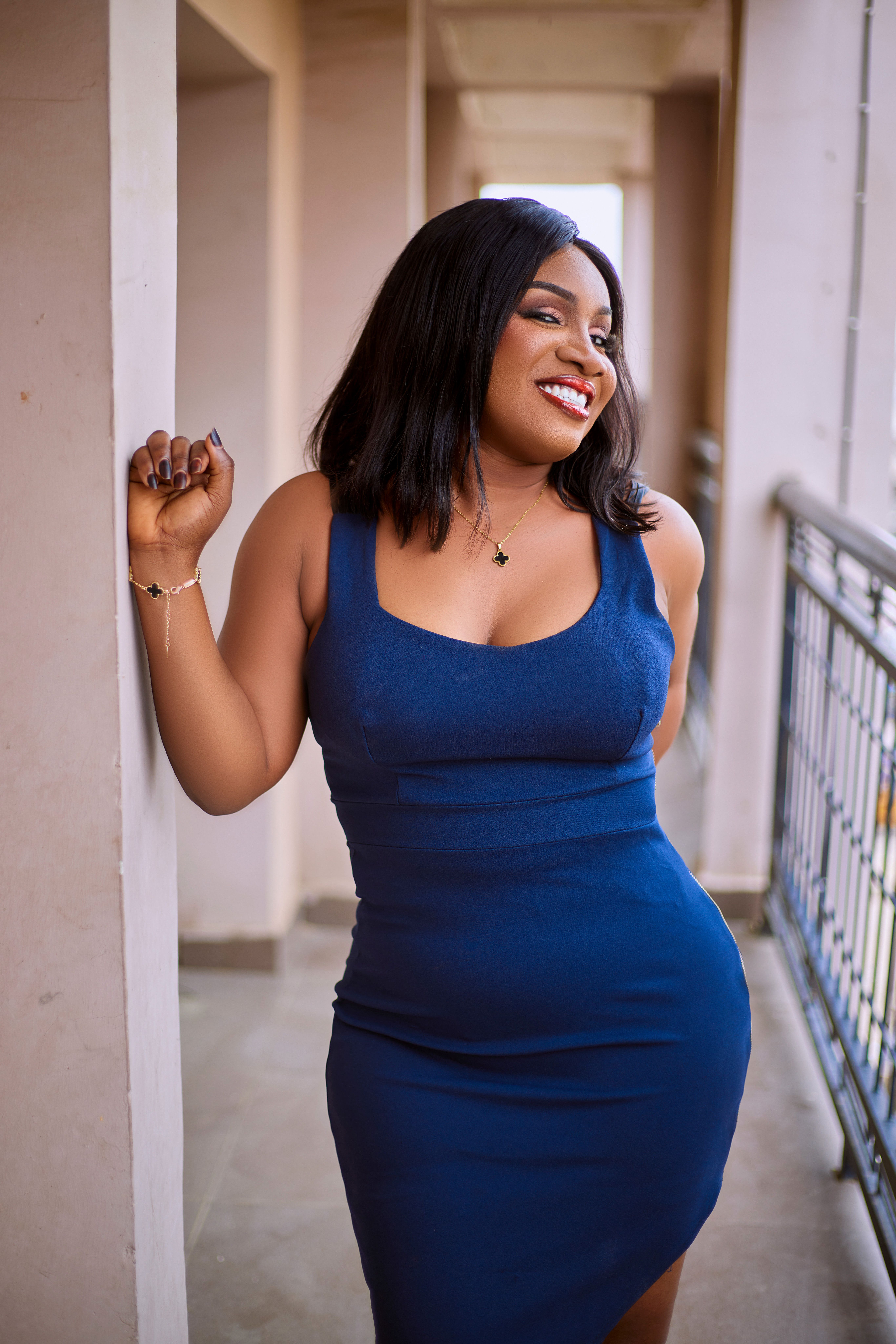 Happy Woman in Blue Dress Leaning on Wall · Free Stock Photo