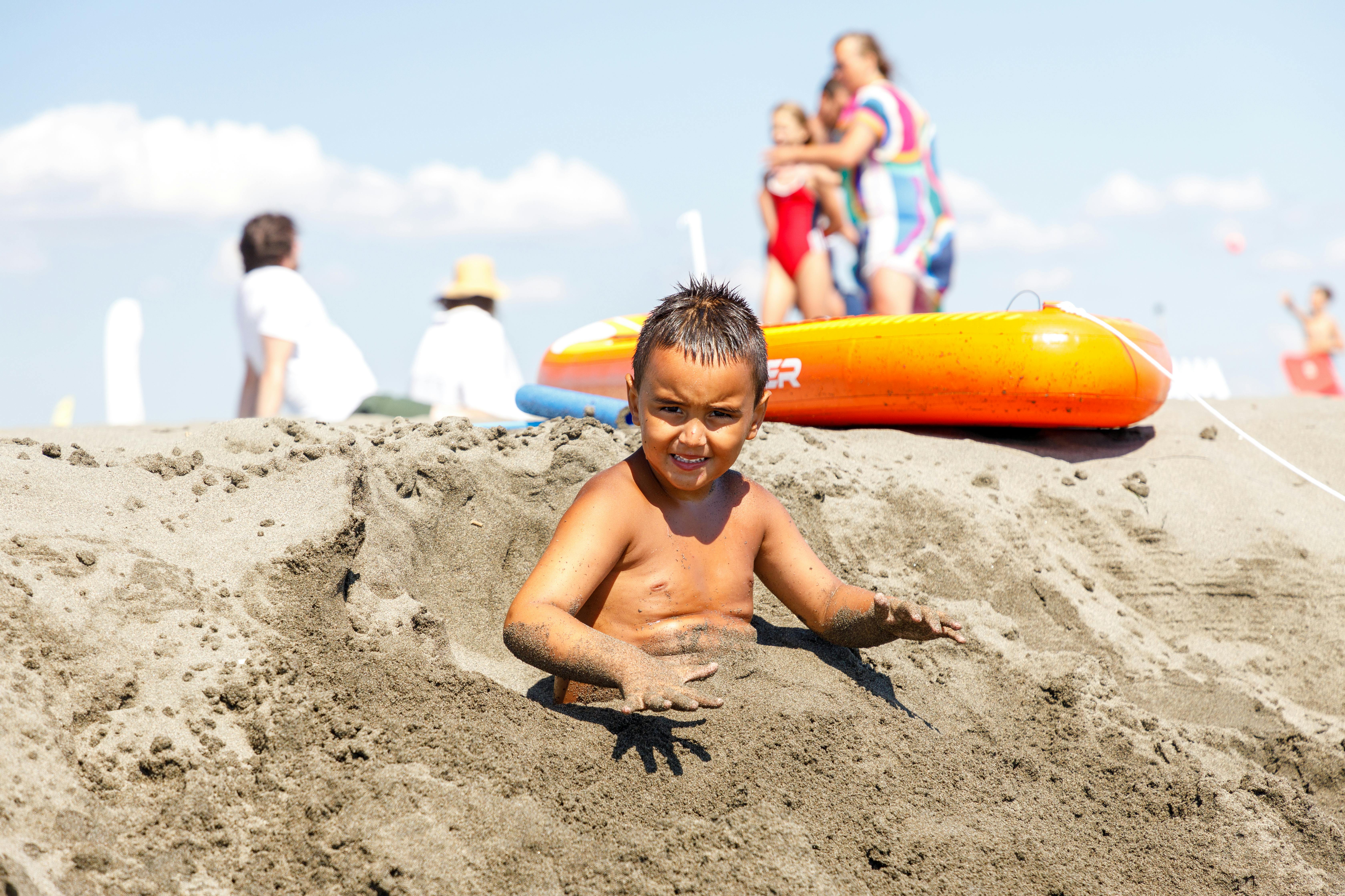 A young boy plays in the sand on a sunny day at Ulcinj beach, Montenegro.