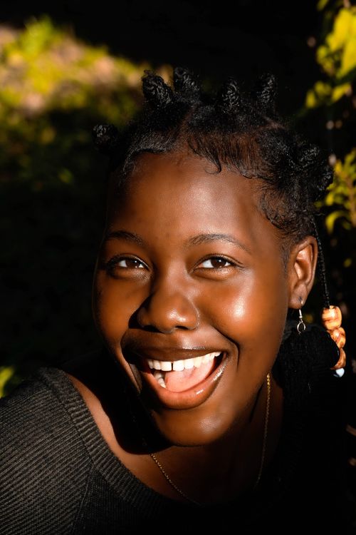 Free A joyful young woman smiling brightly in outdoor sunlight in Mozambique. Stock Photo