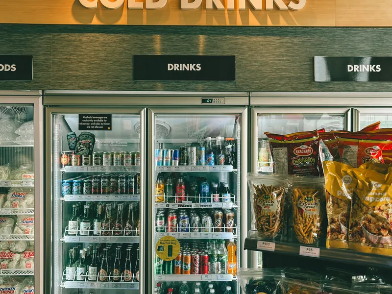 Convenience store aisle with refrigerated drinks and snacks Convenience store aisle with refrigerated drinks and snacks