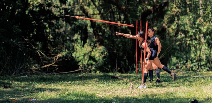 Two women practicing javelin throw outdoors in a lush forest setting in Colombia. — photo by CRISTIAN CAMILO  ESTRADA