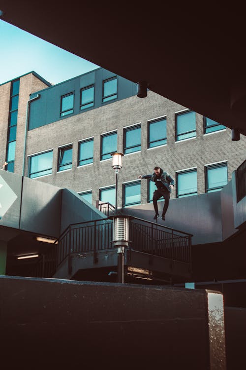 Man Wearing Gray Jacket While Jumping in Midair