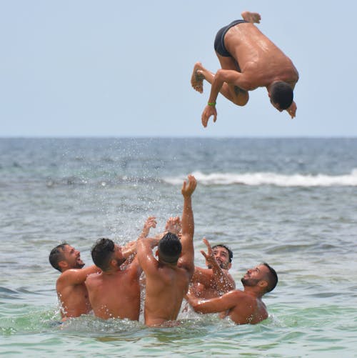 Group of Men in Body of Water