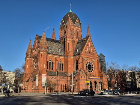Stunning view of a historical red brick church under a clear blue sky in Berlin, Germany.
