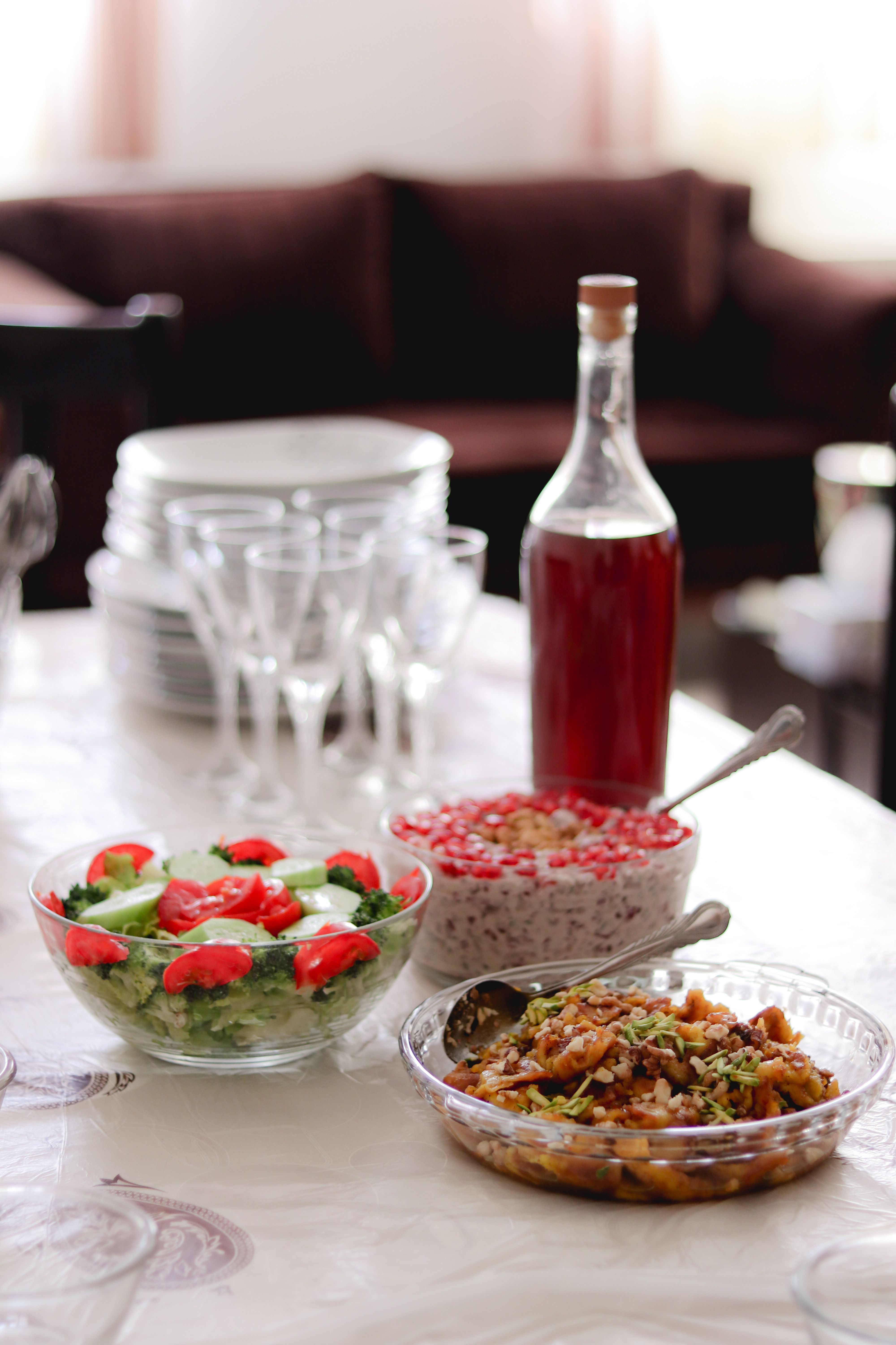 A beautifully set dining table with salads, dessert, and bottled beverage, highlighting colorful culinary presentation.