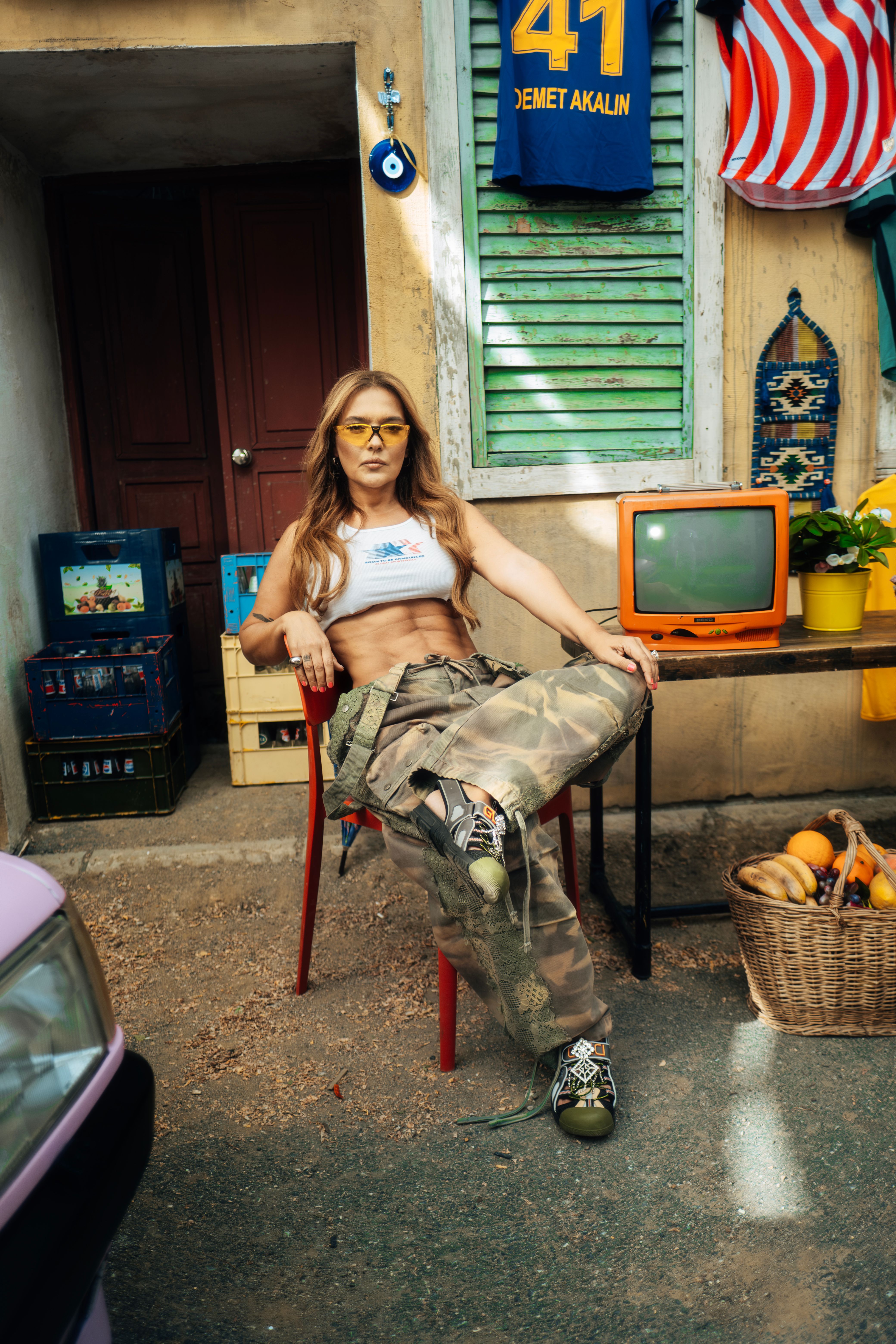 Woman in casual attire poses outdoors with retro decor, warm vibe.