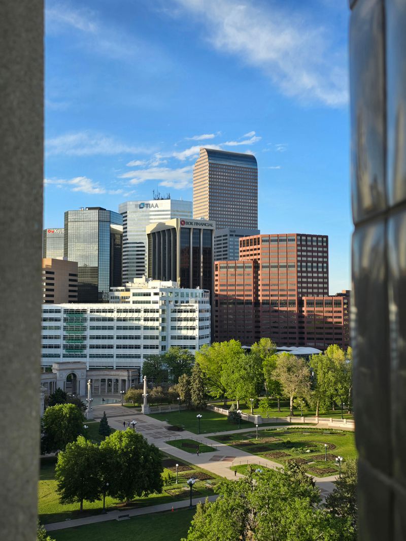 Modern Denver skyline with distinctive skyscrapers and lush greenery below