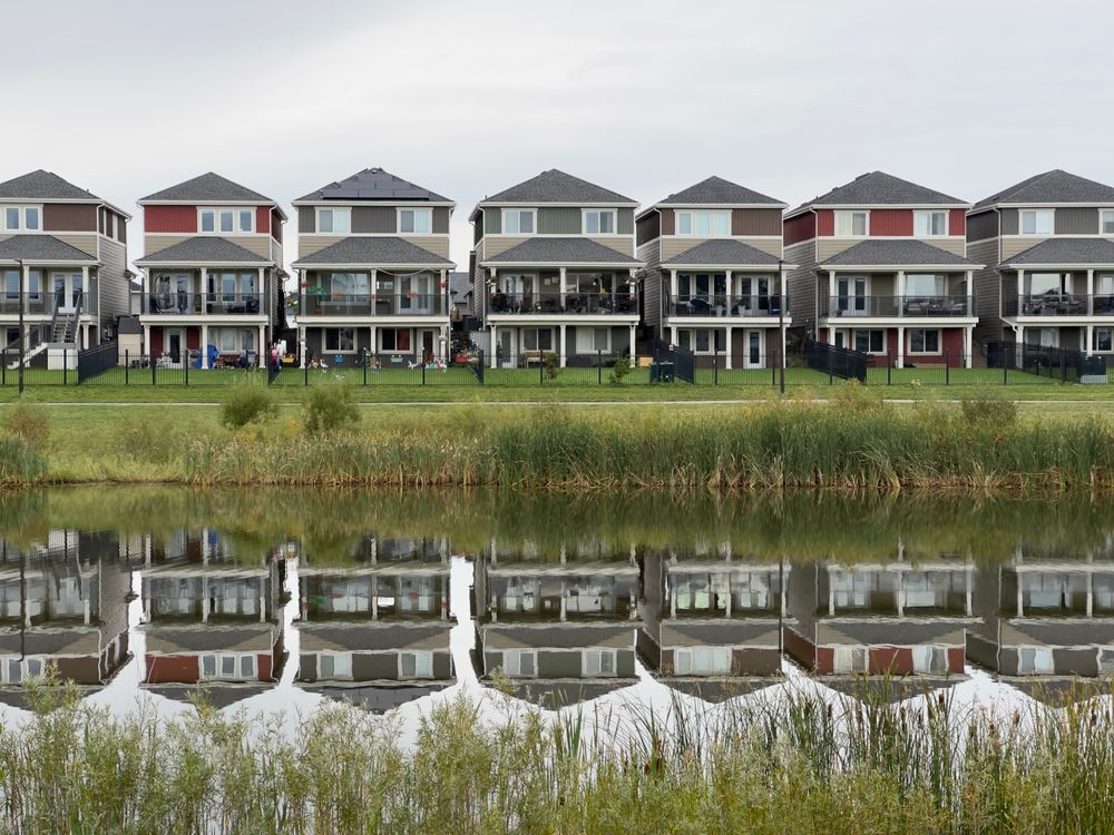 A row of modern houses reflected in a pond among new homes for sale in Summerlin NV