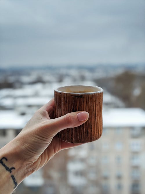 Persona Sosteniendo Taza Marrón