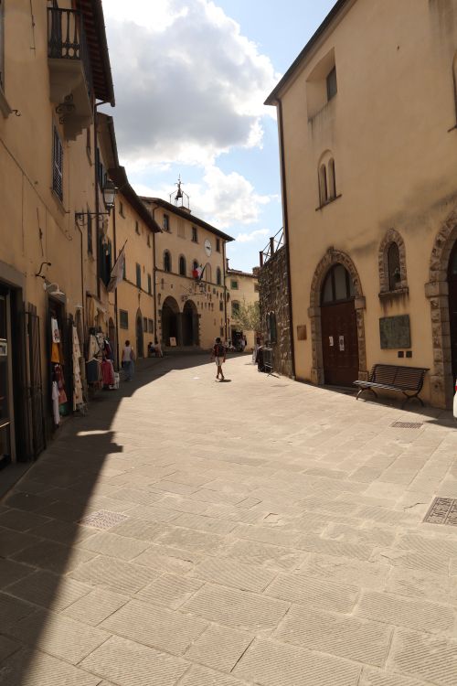 Free A quaint Italian street bathed in afternoon sunlight, capturing architectural charm. Stock Photo