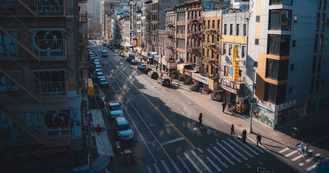 Street view of Chinatown in New York City with pedestrians and historic buildings.