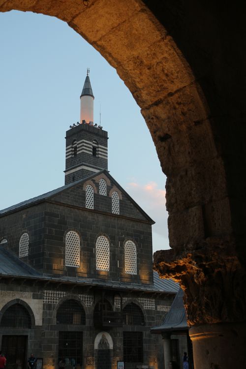 Free Capture of a historic mosque through an arch at dusk, enhancing its architectural beauty. Stock Photo