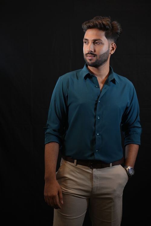 Free Studio portrait of a confident South Asian man in a sea green shirt, embodying modern style. Stock Photo