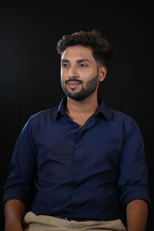 Free Studio portrait of a young man in a navy blue shirt. Professional and confident look. Stock Photo