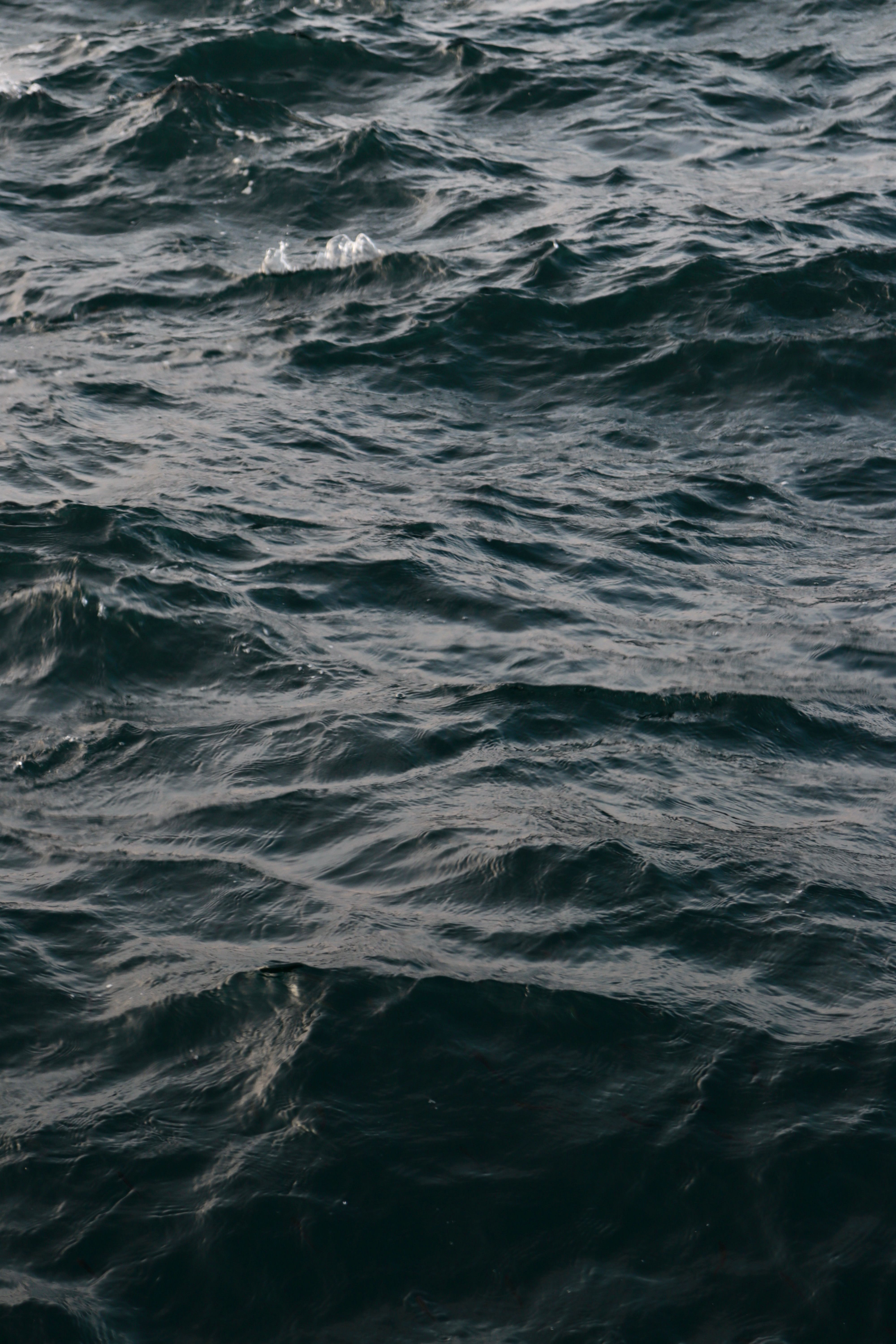 Aerial view of dark ocean waves in motion, evoking a sense of mystery and depth.