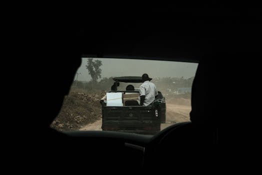 A pickup truck journey on a dusty unpaved road in Mwanza Region, Tanzania.