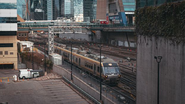 View of train passing through financial district with modern skyscrapers in Toronto, Canada.