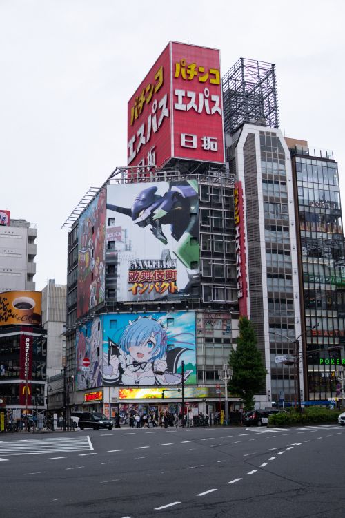 Free Vibrant Tokyo street featuring large anime billboards and urban architecture. Stock Photo