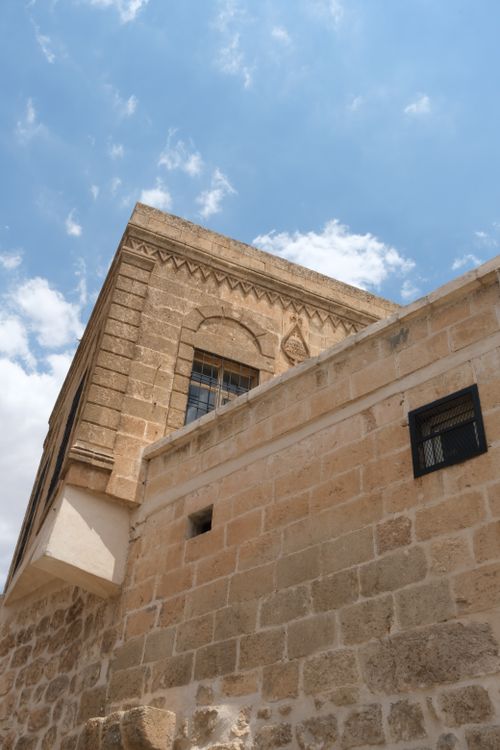 Free View of a historic stone building under blue sky with clouds. Stock Photo
